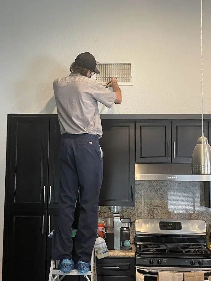 Technician inspecting an air vent during HVAC service in Marengo